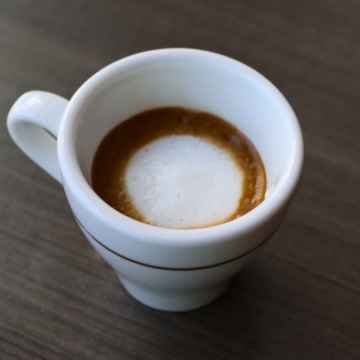 Macchiato with Opus Espresso and dollop of foam in a small espresso cup.