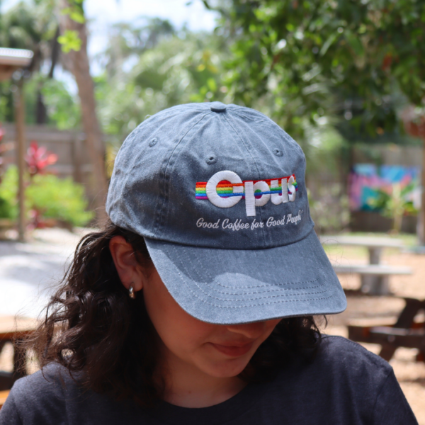 Girl wearing an Opus Pride hat that says "good coffee for good people.