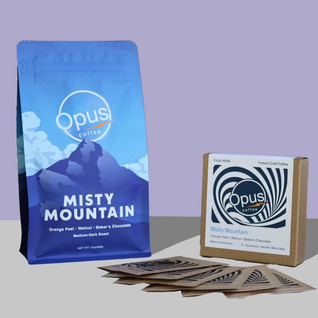 Misty Mountain Retail 12oz bag with mountains on it and Flash Brew 6 packet on a light purple background.
