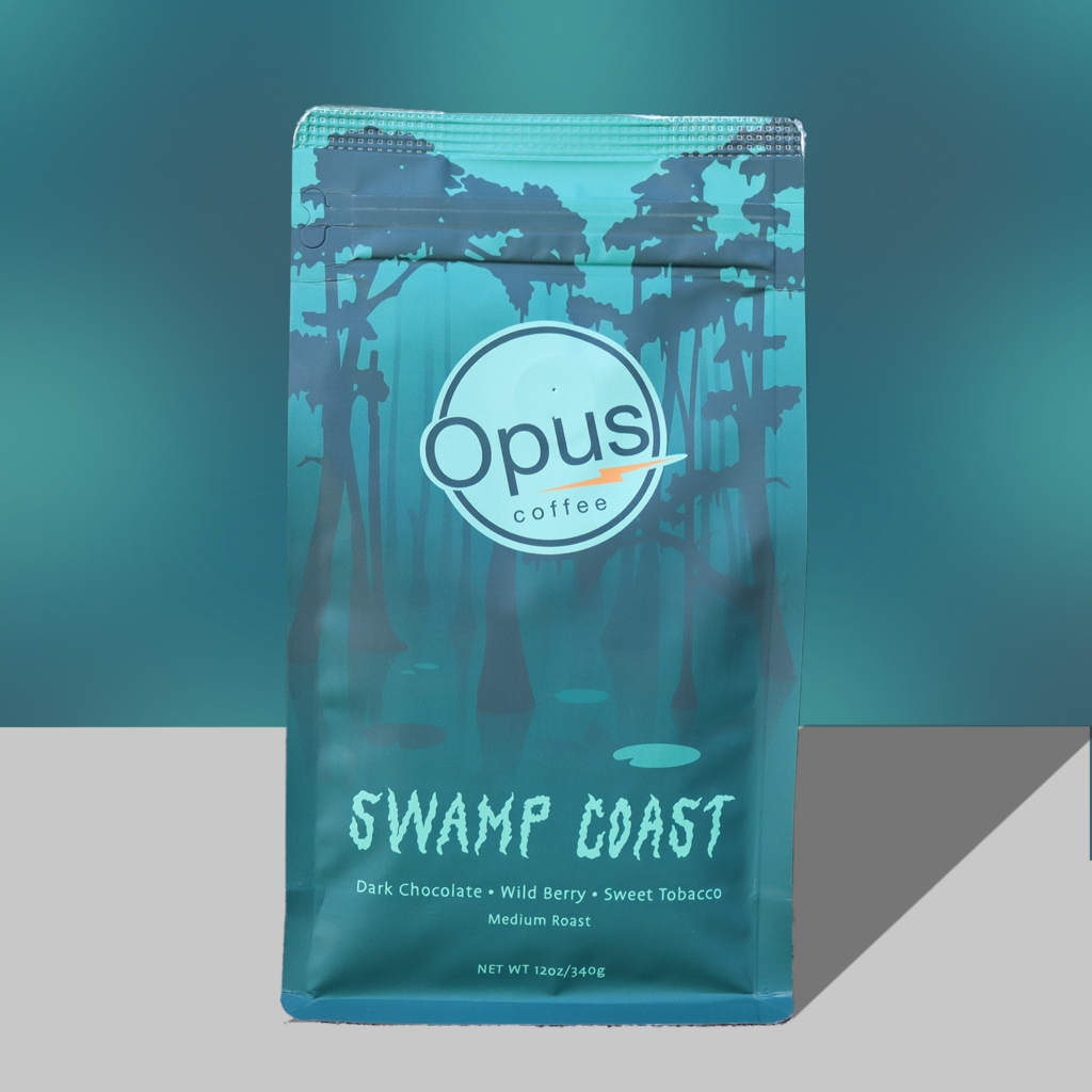 The Opus Coffee Swamp Coast custom bag on a bluish green background.