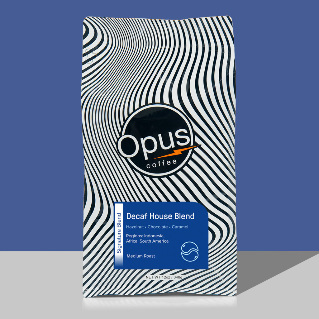 Opus coffee retail bag with green label that reads, "Decaf House Blend" and cupping notes. The bag is on a blue background.