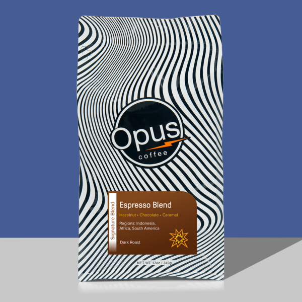 Opus coffee retail bag black and white wavy design with dark brown label that reads, "Espresso Blend" and cupping notes. The bag is on a blue background.