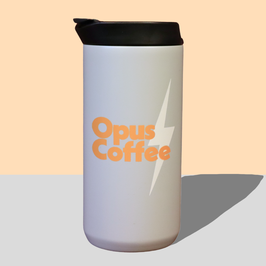 Gray mug with black lid with Opus Coffee in orange.