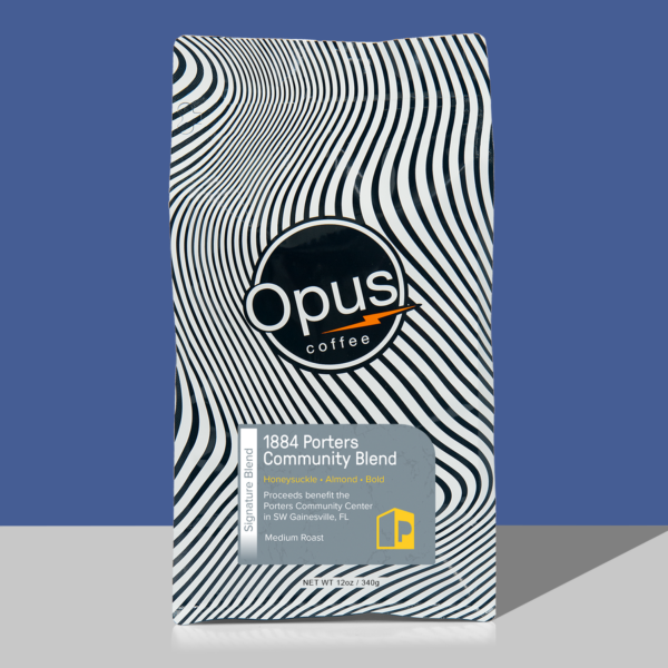 Opus coffee retail bag black and white wavy design with gray label that reads, "1884 Porters Quarters Blend" and cupping notes. The bag is on a blue background.